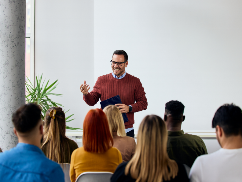 Man presenting to a group in classroom.