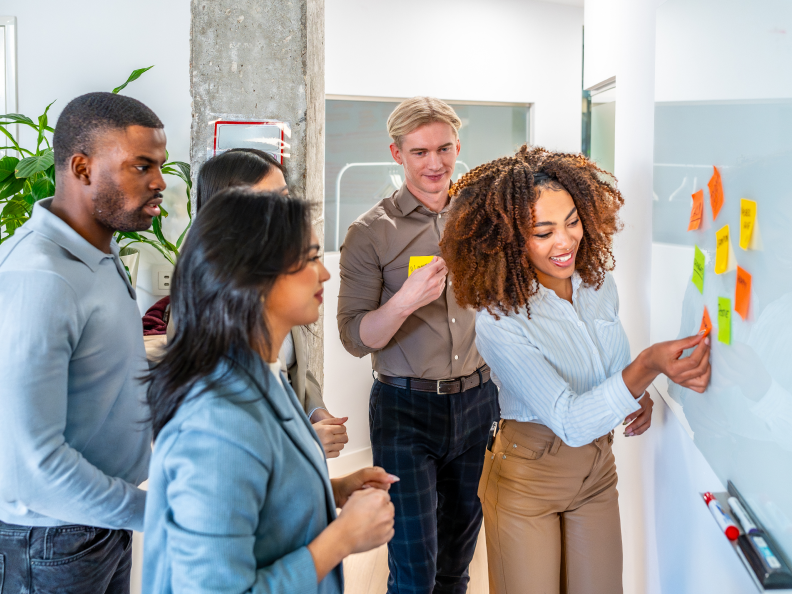 Team brainstorming with sticky notes on board.